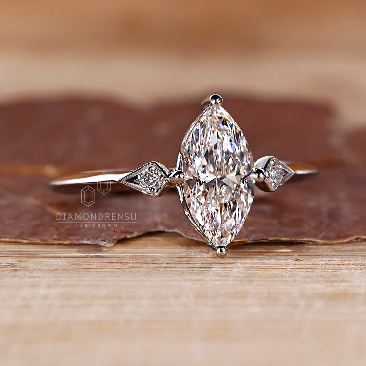 White gold engagement ring featuring marquise and round diamond design.
