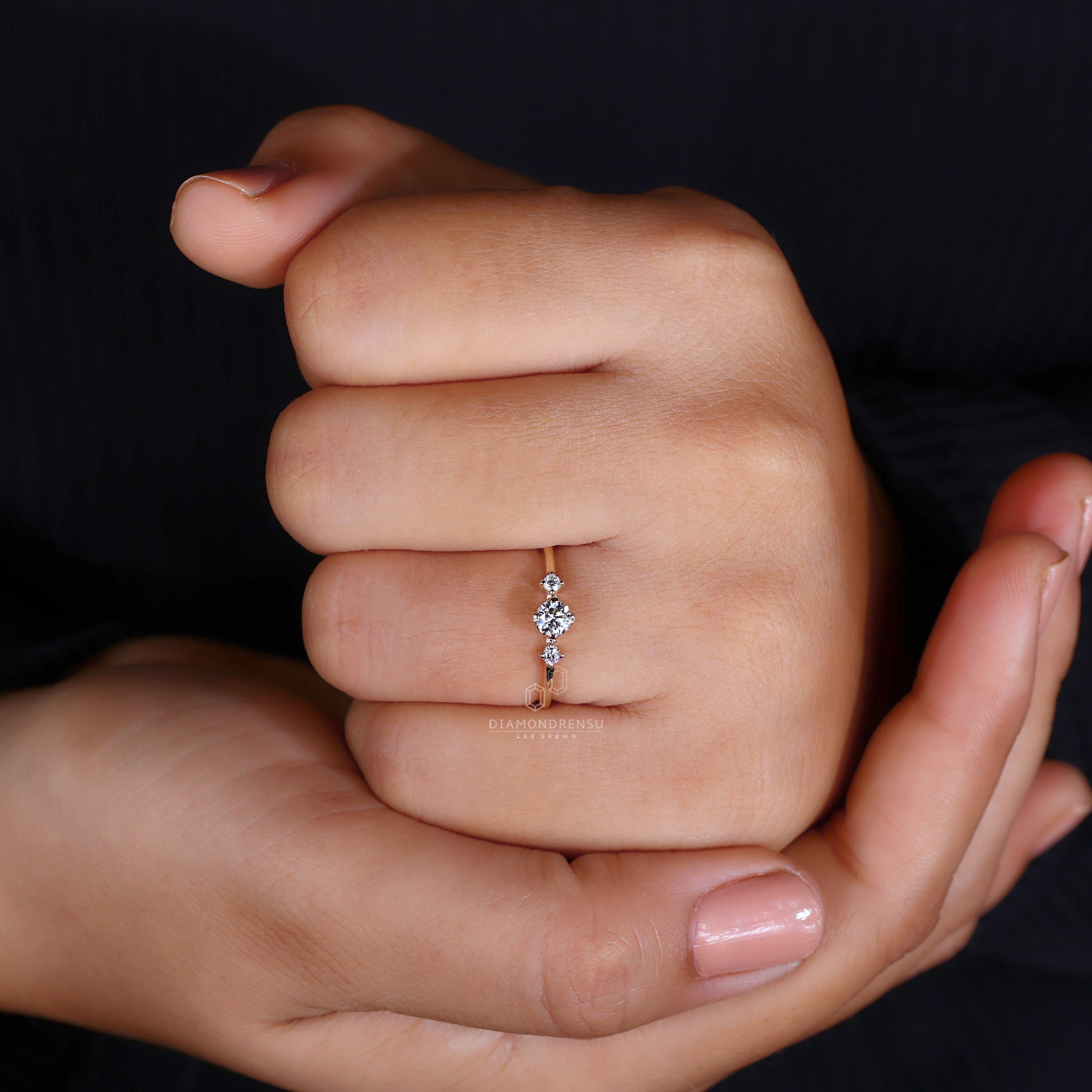 Round engagement ring with side stones, showcasing a three stone diamond ring with compass prongs