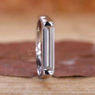 Diamond ring solitaire with baguette cut diamonds on a display stand
