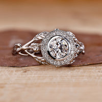 White gold engagement ring with intricate milgrain detailing and a sparkling halo setting.
