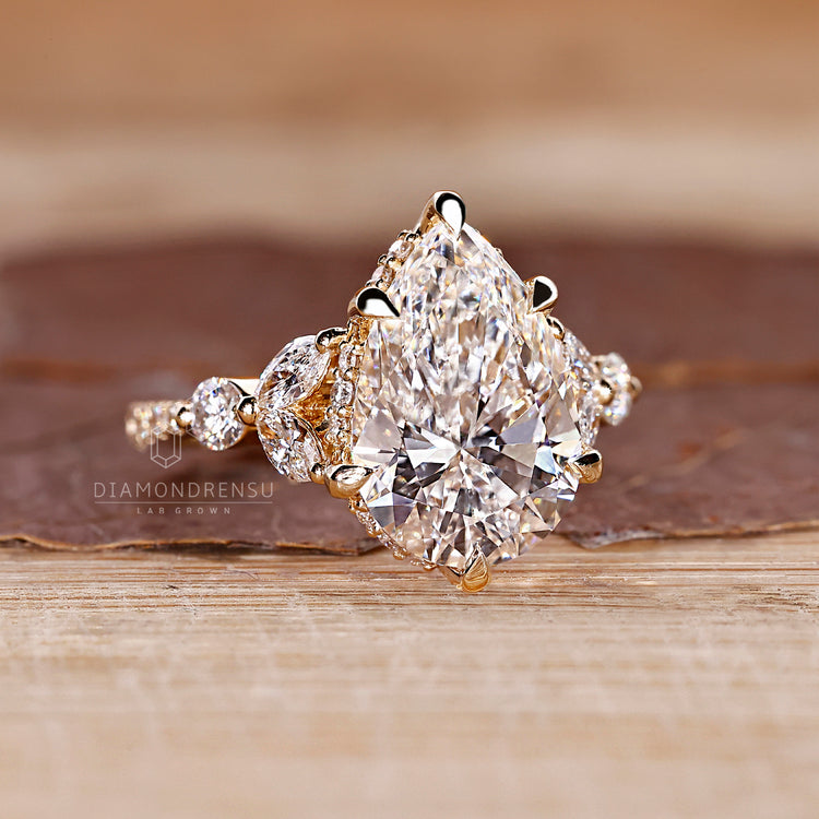 Tapered shank ring with pear cut diamond and tulip muse setting.
