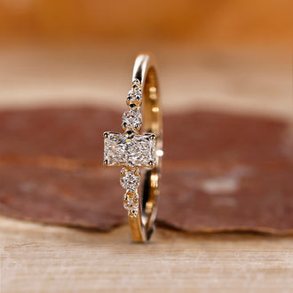 Radiant Cut Engagement Ring with round cut side stones in yellow gold.

