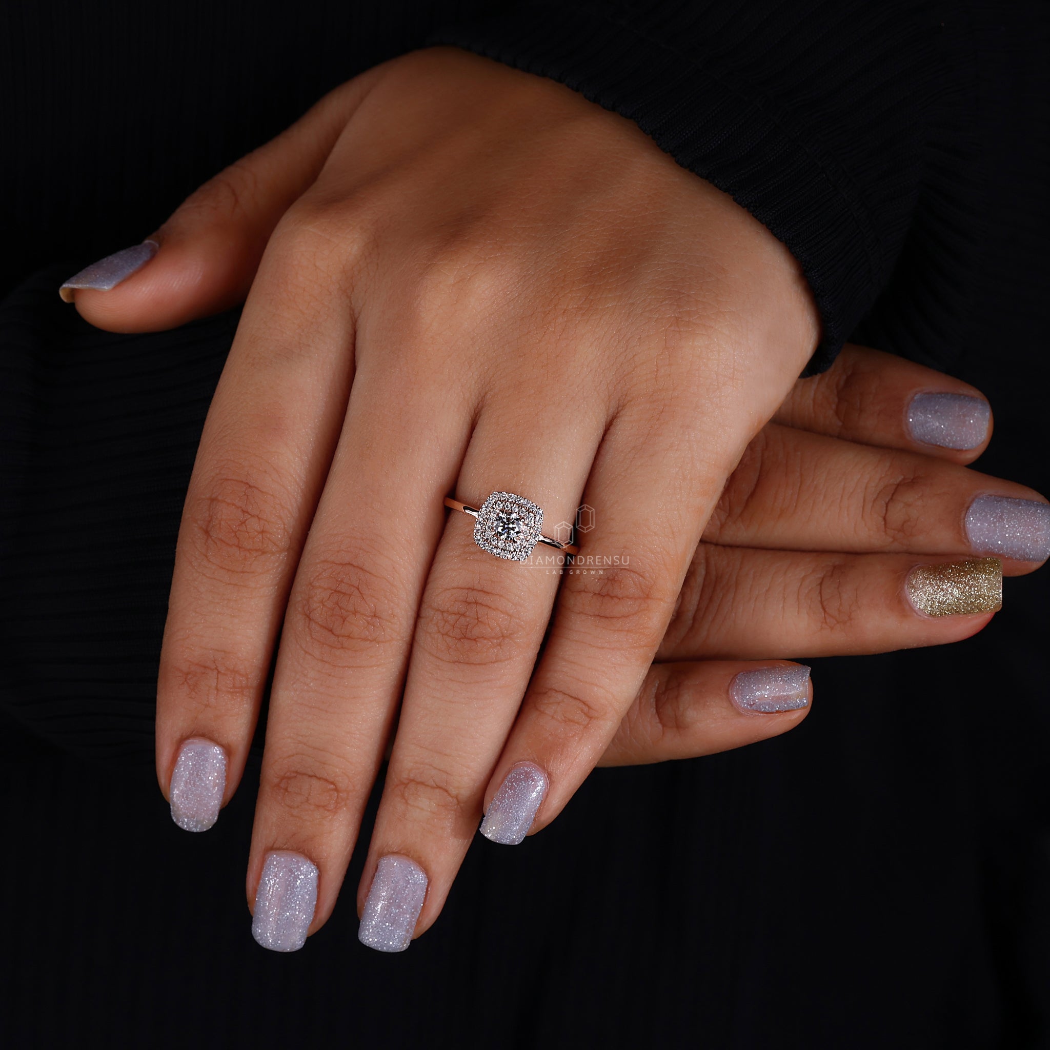 An image of a double halo ring on a female model's finger, featuring a magnificent round brilliant cut diamond, beautifully framed by two halos of smaller diamonds on an intricate white gold band.