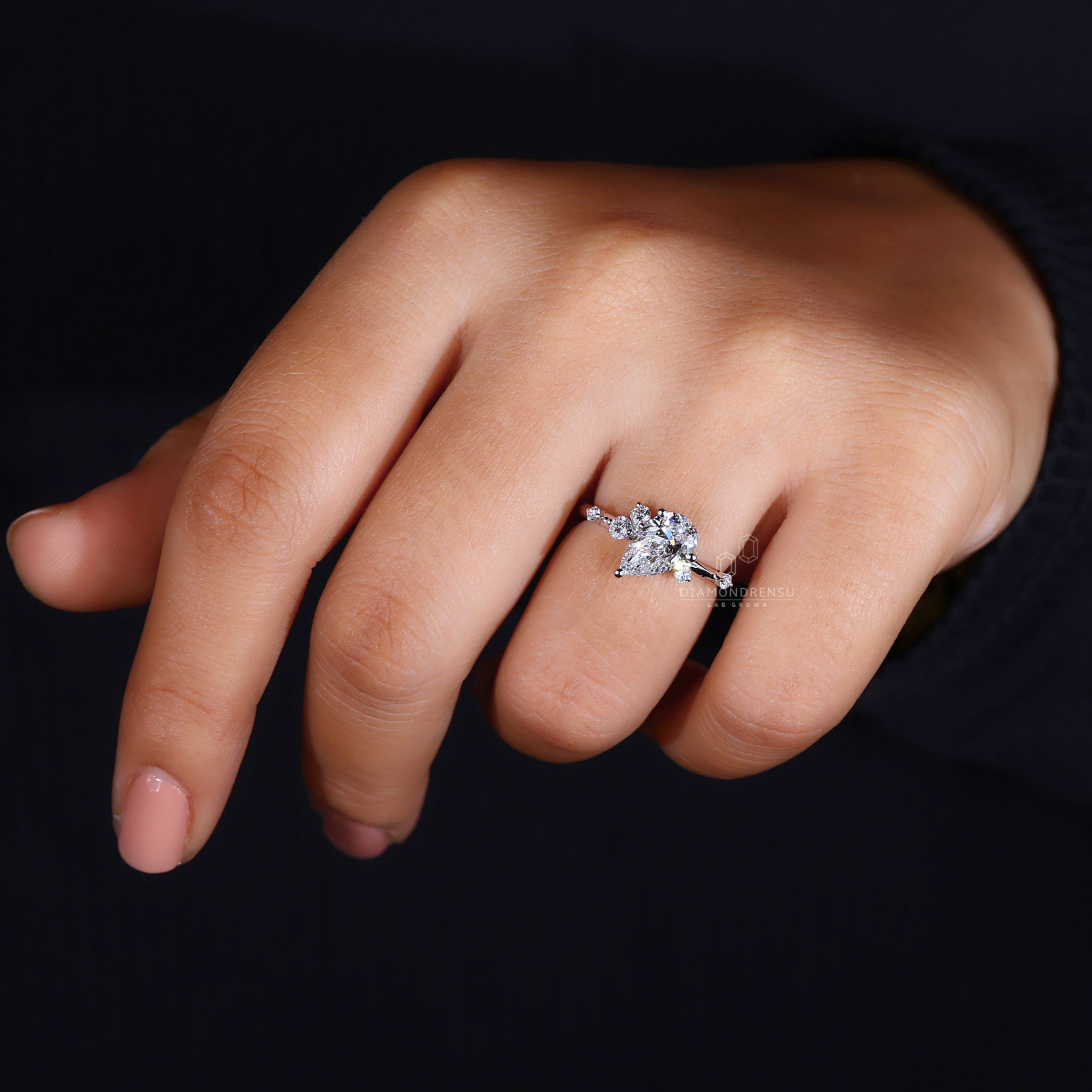 Model wearing a beautiful pear cut engagement ring with a white gold band