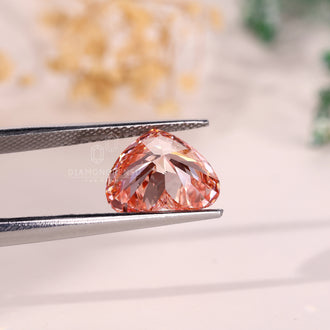 A fancy vivid pink diamond in heart cut is shown as a 4 carat loose diamond.
