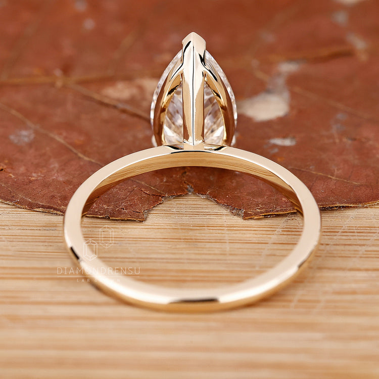 Custom engagement ring with a pear-shaped diamond, made to fit her style.
