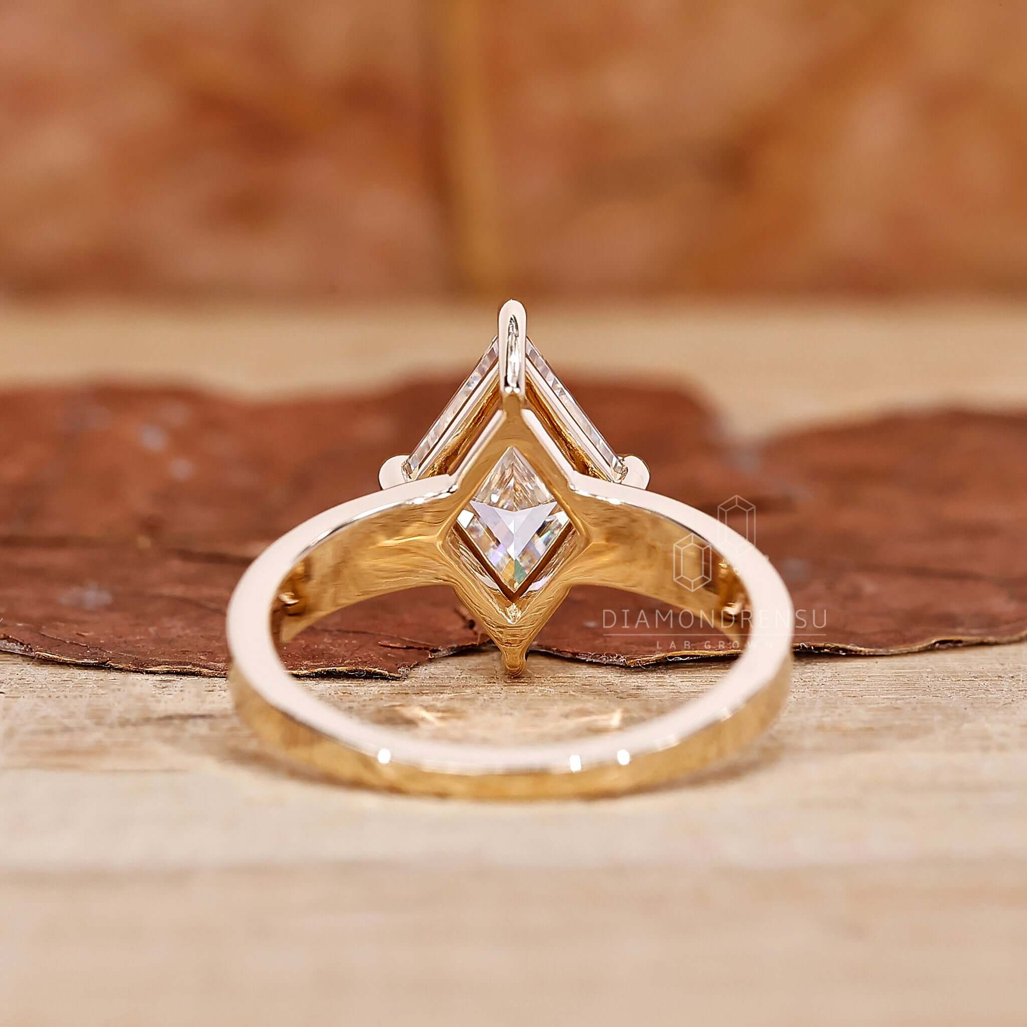 A side profile shot of a gold engagement ring adorned with a captivating lozenge cut diamond, symbolizing eternal love and commitment.
