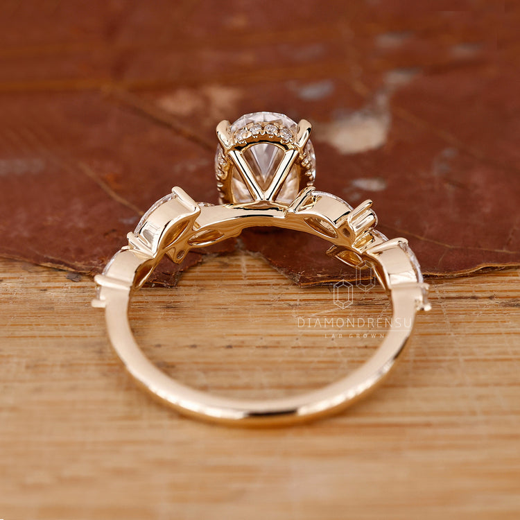 Yellow gold ring with an oval centre stone and hidden halo design.
