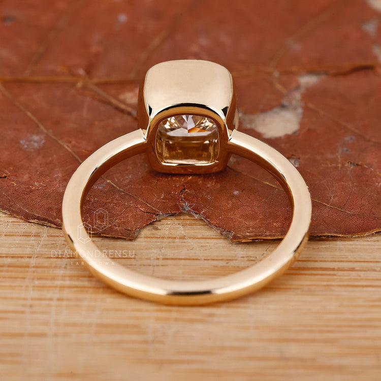Lab Grown Diamond bezel set engagement ring with a cushion diamond for a sustainable choice.
