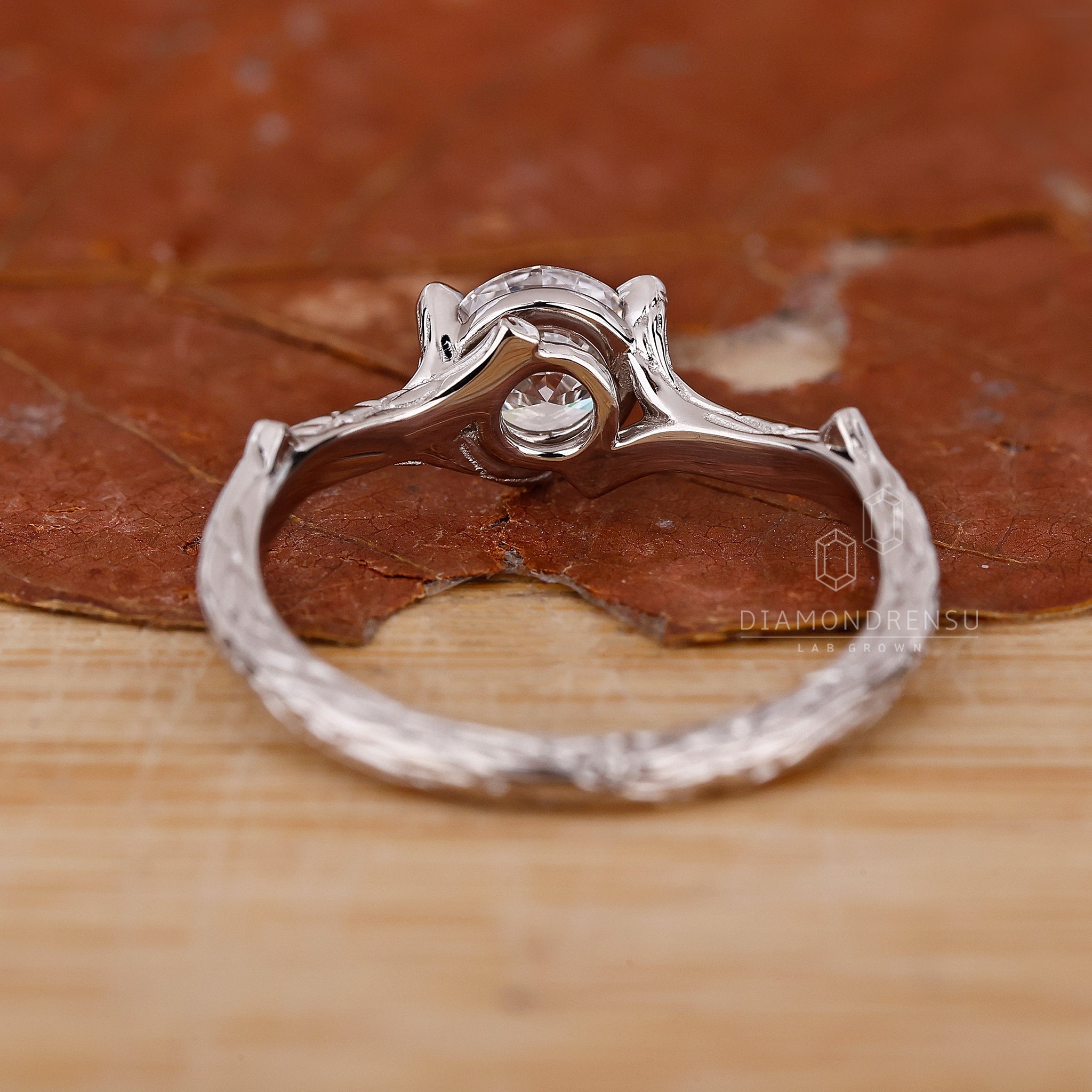 Nature-inspired wedding ring with a round cut diamond, beautifully set in a white gold band with branch designs.