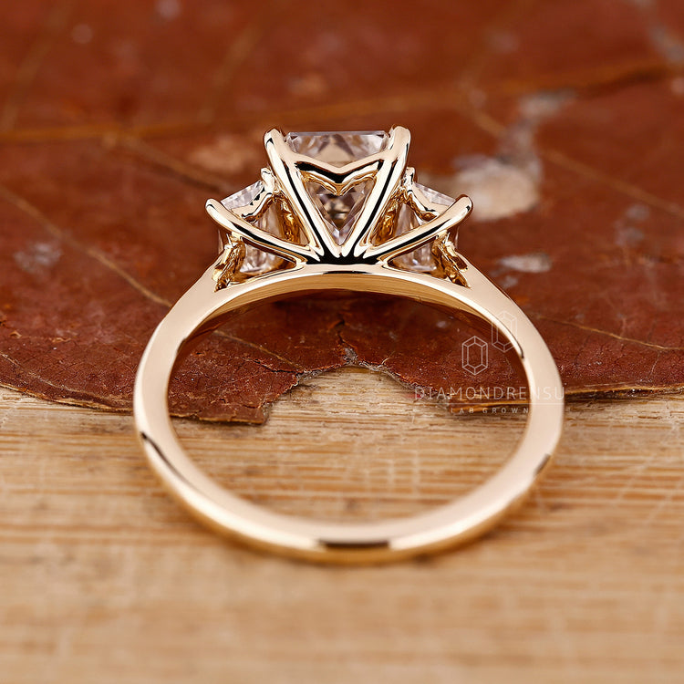 Elegant cathedral engagement ring with a three stone emerald cut design.
