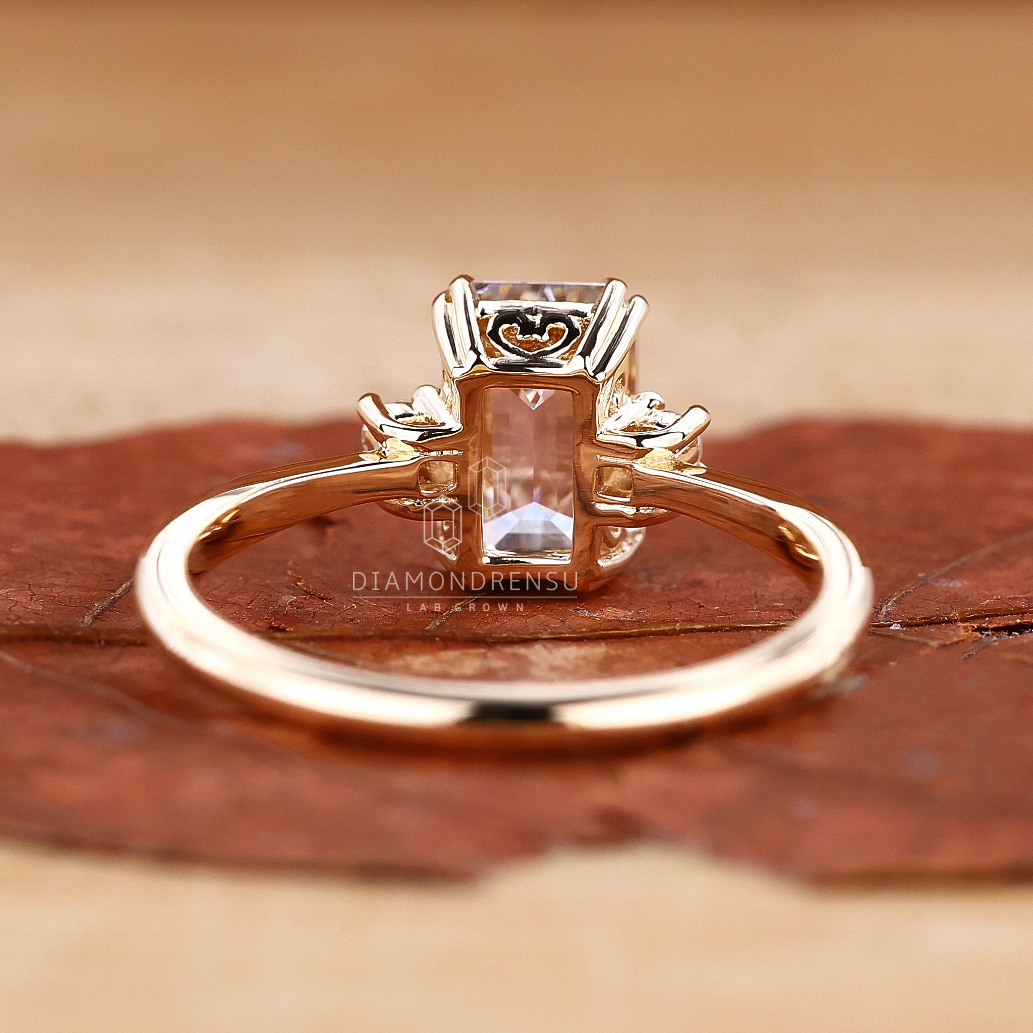 Detailed view of an emerald cut diamond in a classic three stone ring setting