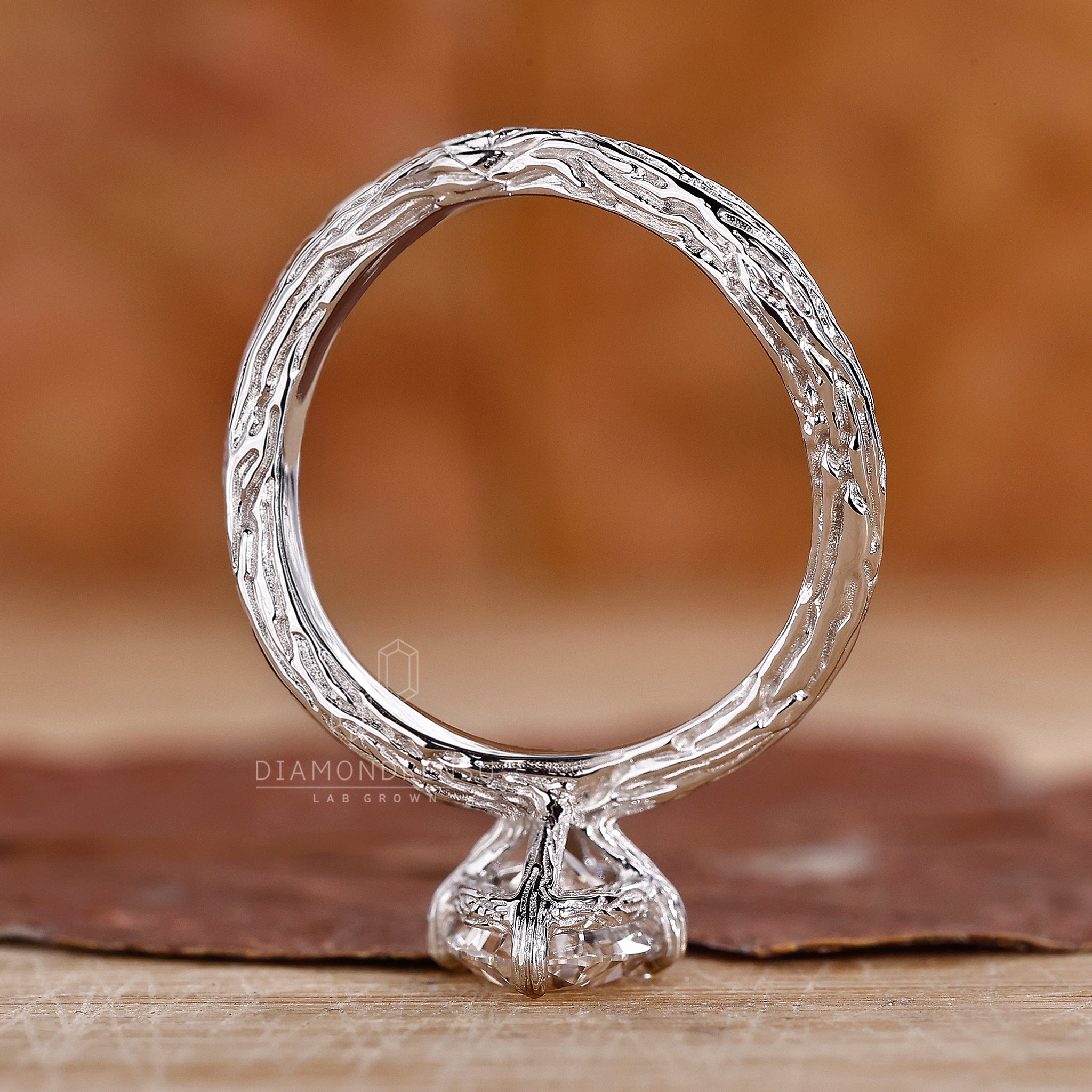 Beautiful oval solitaire diamond ring photographed in a natural setting. The nature-inspired design features claw prongs and a handmade band by Diamondrensu, IGI certified.