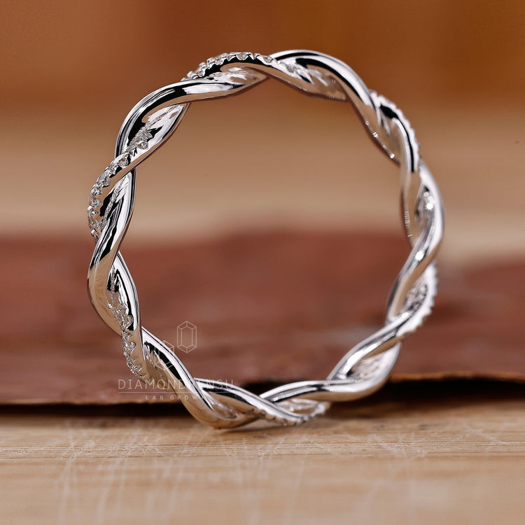 Twisted pave wedding band featuring delicate diamond accents.
