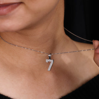 Hip hop style pendant with prong set round diamond in custom design.
