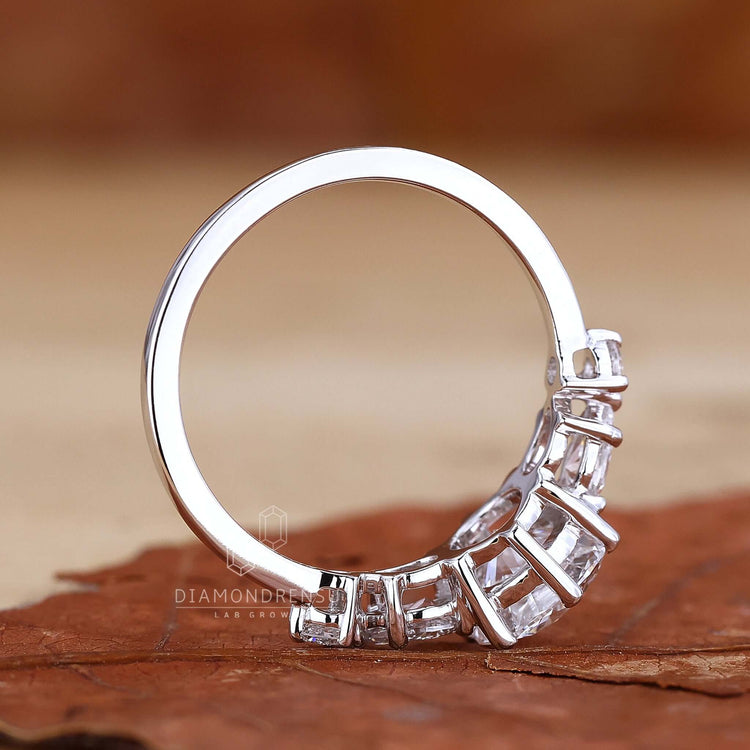 Hand delicately holding a simple diamond ring, emphasizing its delicate beauty and fine craftsmanship