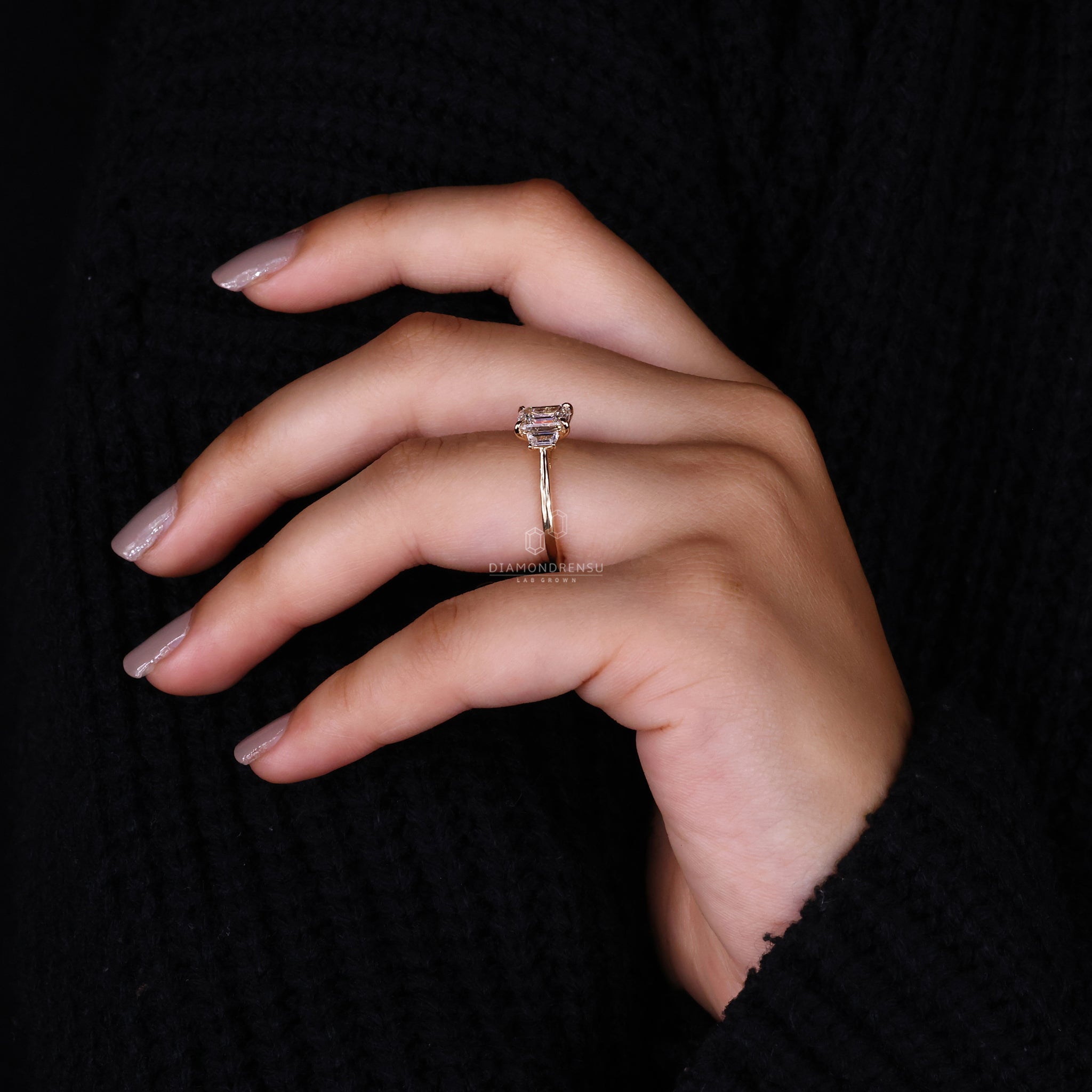 Model displaying the lab created three stones engagement ring with an emerald cut diamond, perfect for expressing undivided love