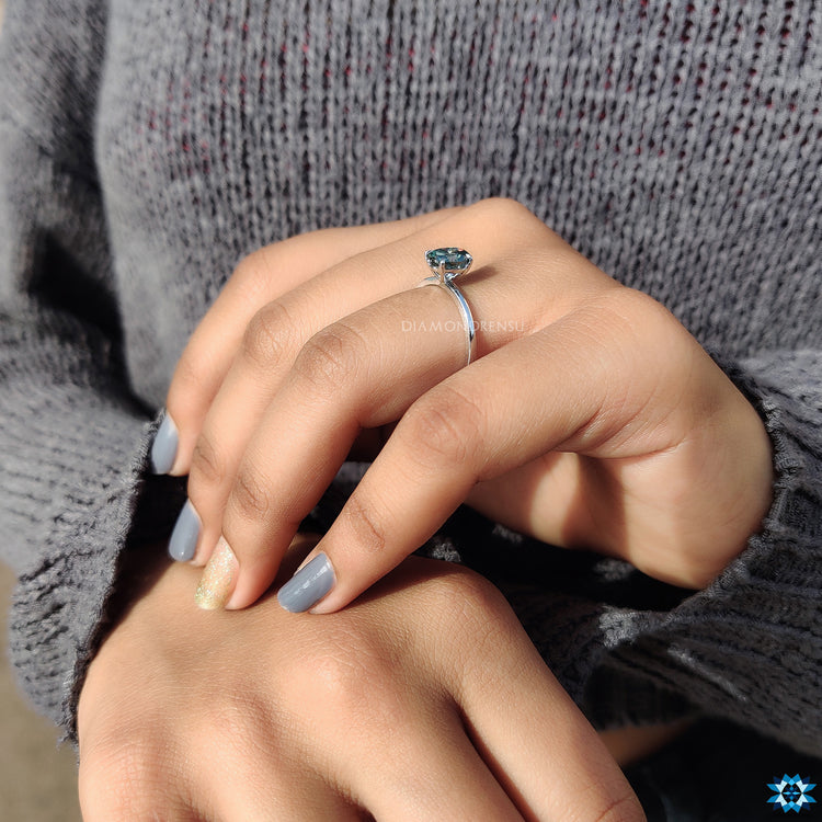 Custom engagement ring featuring cyan blue oval stone.
