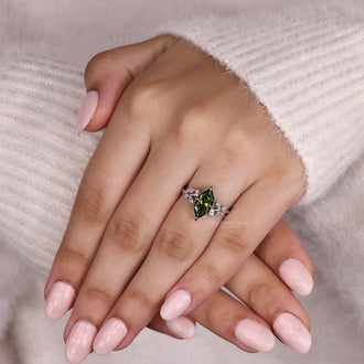 Model wearing a sidestone engagement ring featuring a Dutch marquise diamond and nature inspired design