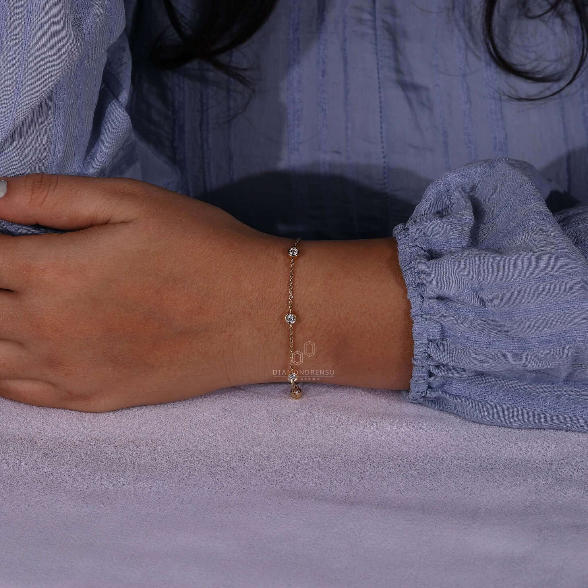 Woman wearing a diamond chain bracelet, sparkling under light.