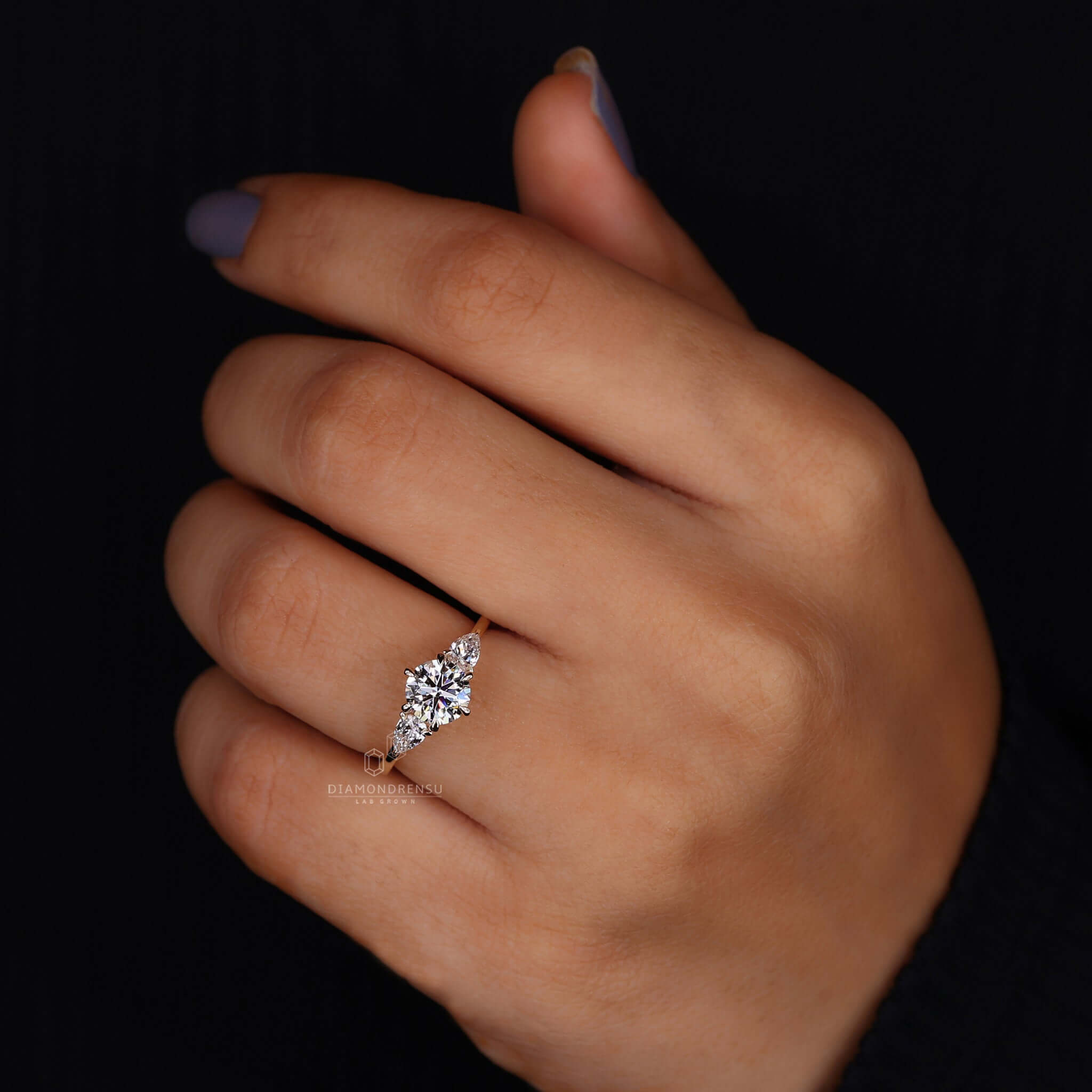 Hand displaying a three stone lab-grown diamond ring, highlighting its ethical beauty and sparkling design