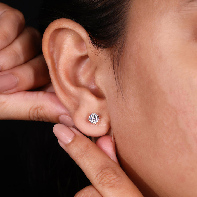 Diamond stud earrings with a radiant 1 carat gemstone in prong setting.
