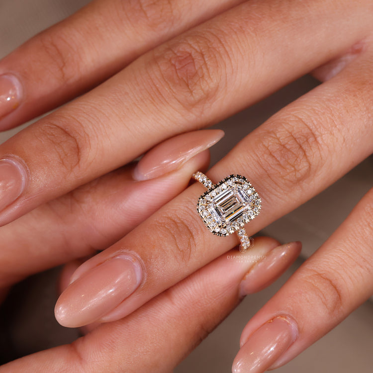 Side stone engagement ring featuring emerald halo.
