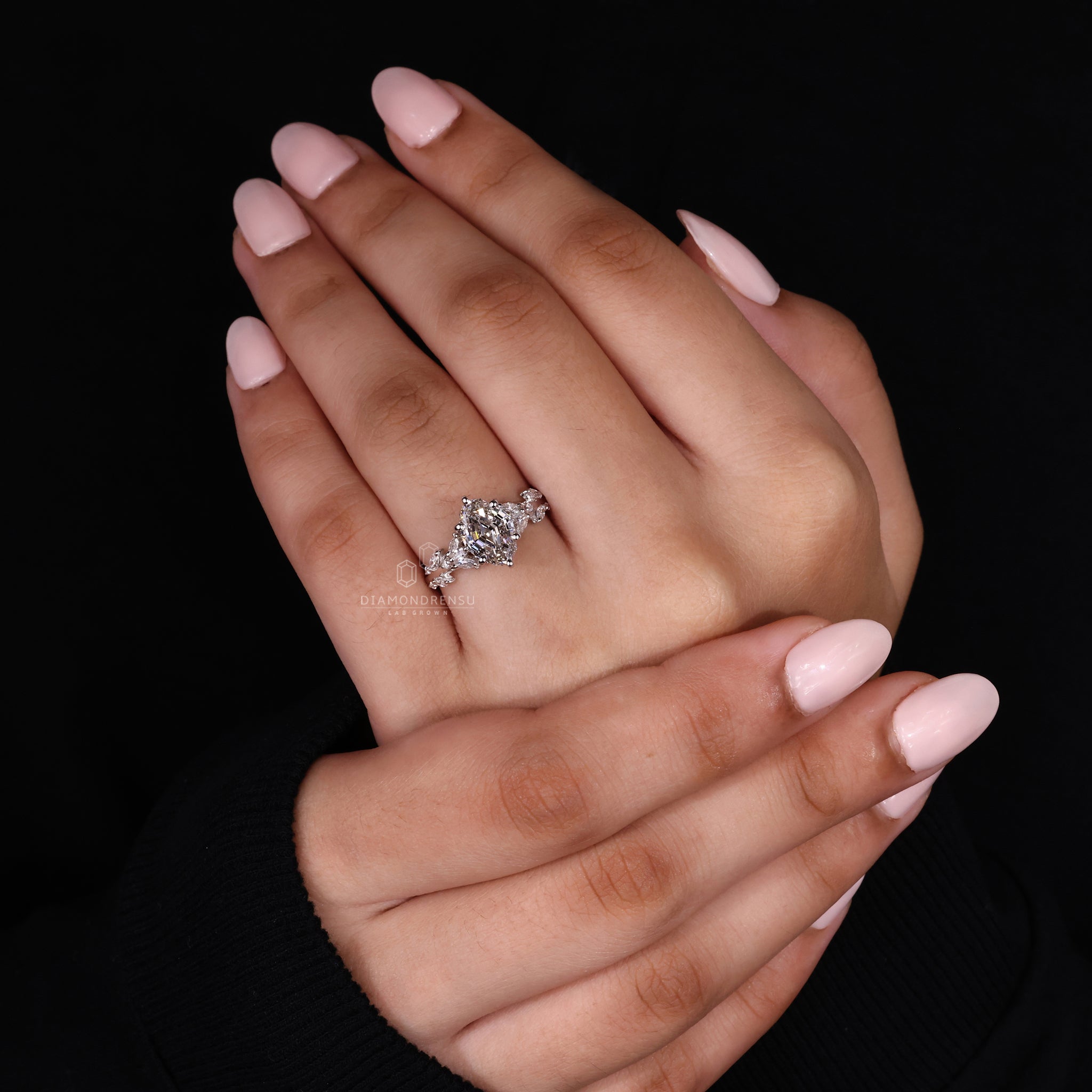 Model wearing an oval shaped engagement ring, emphasizing its natural beauty and step cut diamond.