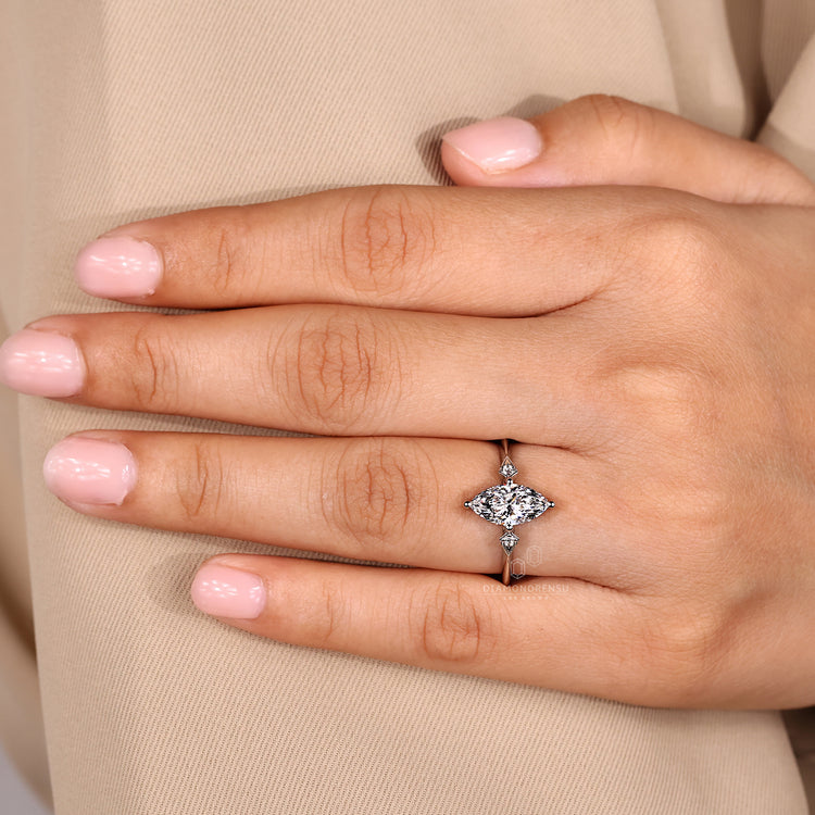 Diamondrensu engagement ring with marquise centre and round side stones.
