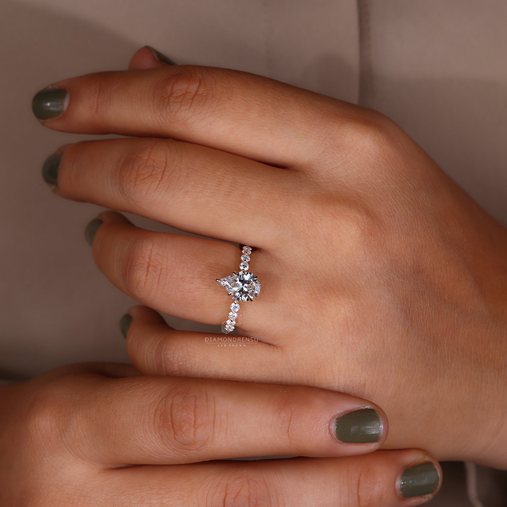 Model highlighting a unique spear cut diamond ring in yellow gold.