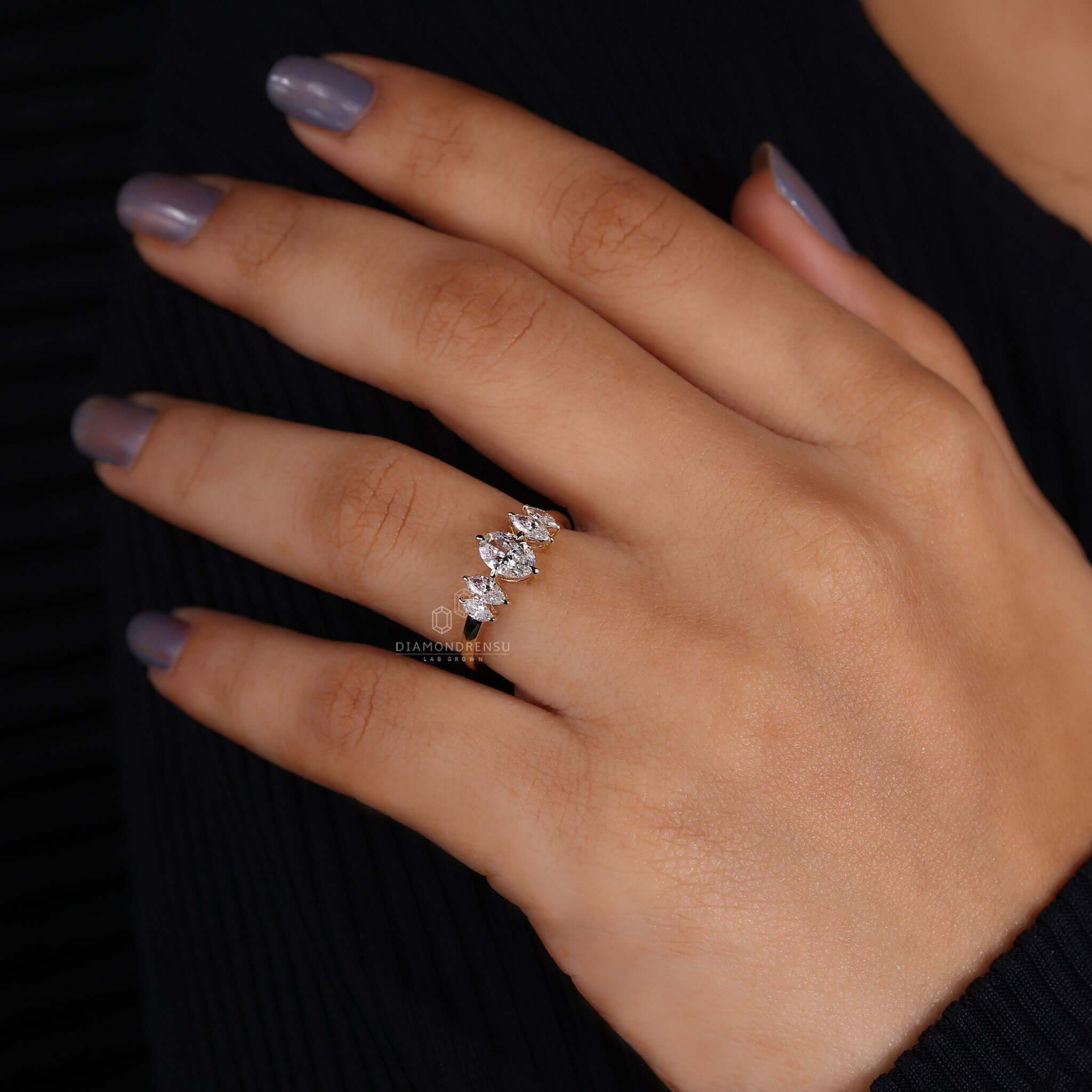 Close-up of a marquise diamond engagement ring on hand, showcasing its distinctive and romantic design