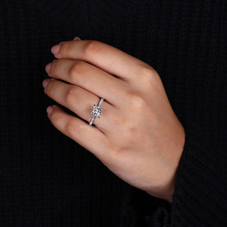 Round cut stone set in a white gold ring for her.
