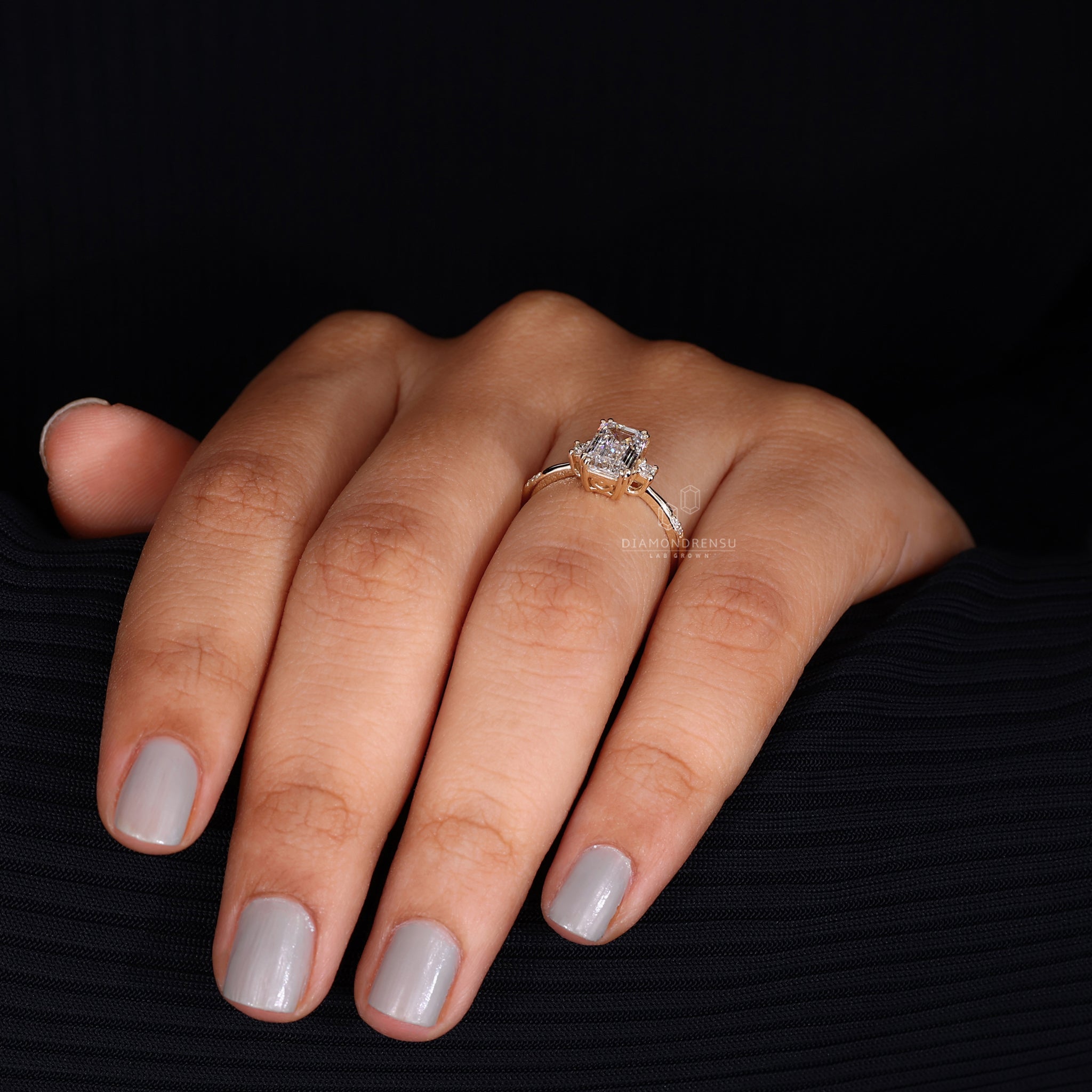 Model's hand gesturing with an emerald cut ring, emphasizing the stone's size and cut