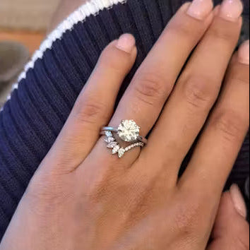 Solitaire diamond ring on a hand over a steering wheel