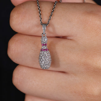Round diamond pendant with prong set design and Bowling Pin charm.
