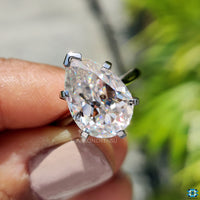 White gold engagement ring with a cathedral setting and pear shape stone.
