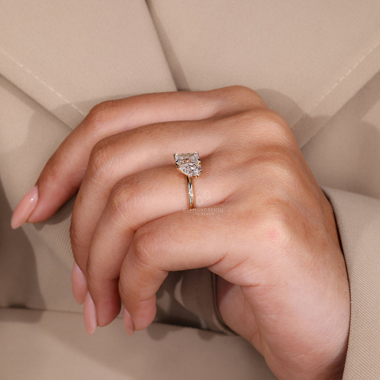 Yellow gold diamond ring with a radiant cut and pear cut design.
