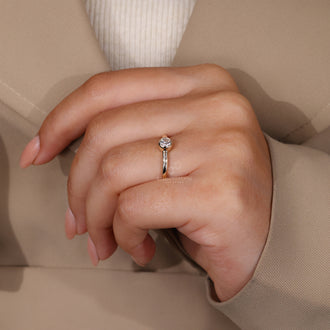 Diamondrensu engagement ring with a bezel setting and round cut diamond.
