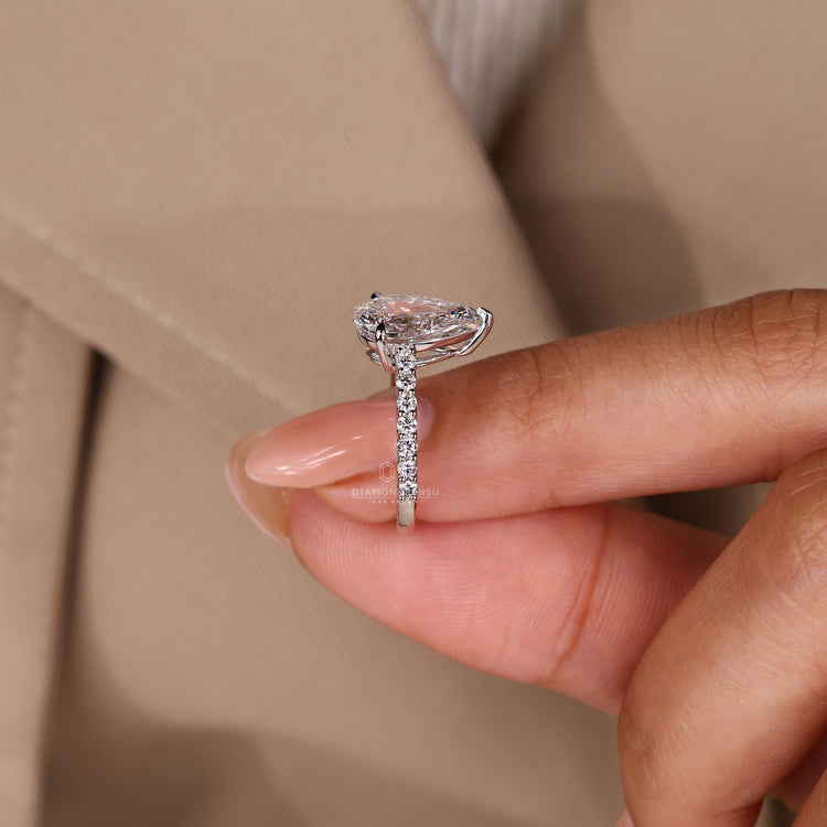 Three claw setting holding a lab grown pear diamond.
