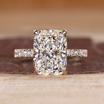 Elongated cushion ring with pave setting in round cut pave band.
