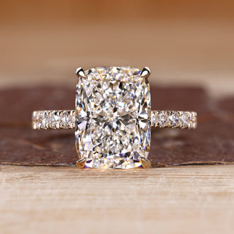 Elongated cushion ring with pave setting in round cut pave band.
