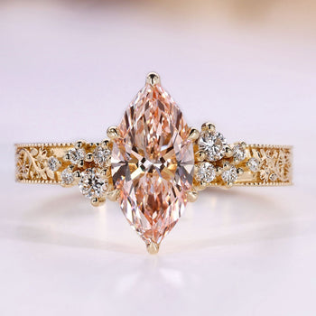 Marquise engagement ring with pink center stone and round side stones.