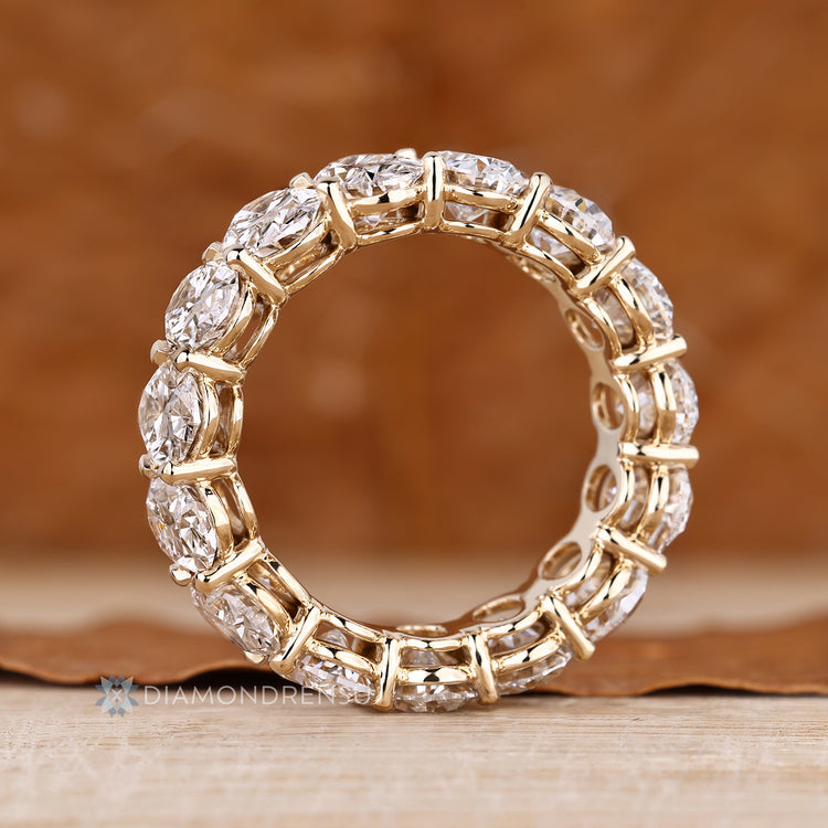 Handmade oval diamond band with basket and shared prong setting.