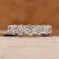 Full eternity wedding band with round diamonds and bezel basket setting.