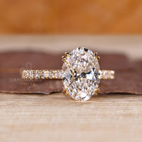 Diamondrensu engagement ring with yellow gold band and double claw prongs.
