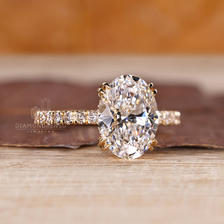 Diamondrensu engagement ring with yellow gold band and double claw prongs.
