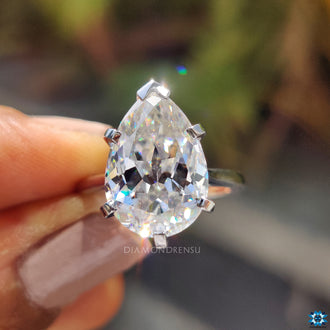 Handmade ring featuring a v prong set pear cut moissanite.

