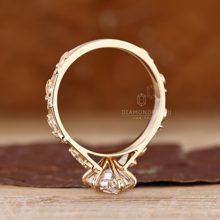 Nature inspired diamond ring with elegant leaf prong and marquise accents.
