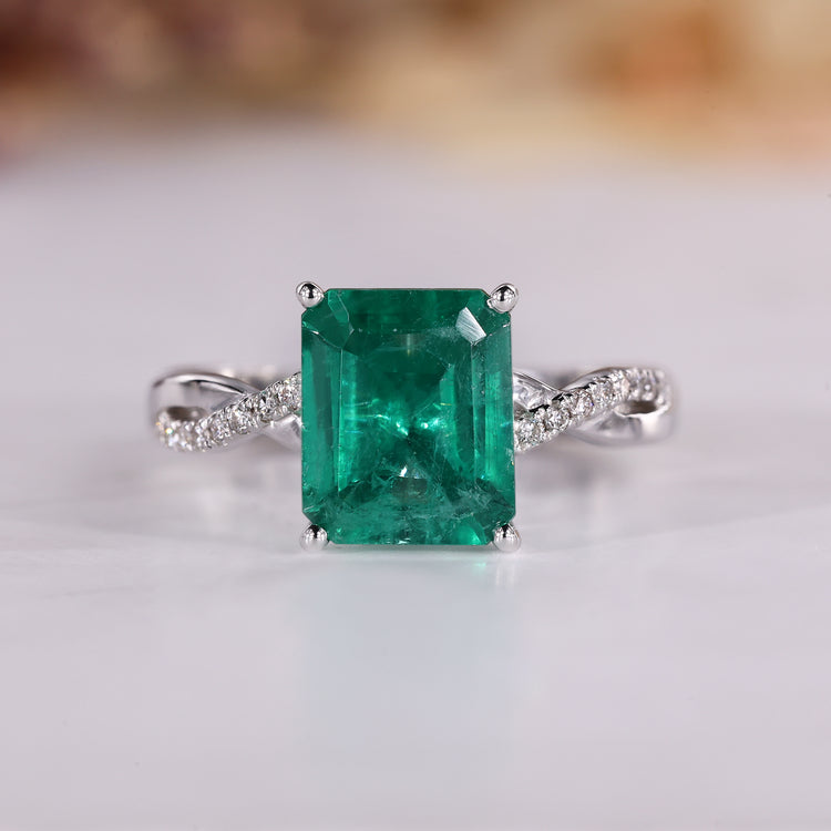 Emerald birthstone ring with green emerald and twisted shank design.
