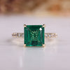 Asscher cut engagement ring with emerald gemstone.
